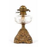 A Victorian oil lamp, with cut glass reservoir and pierced metal base.