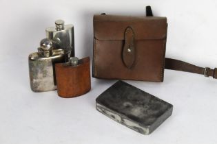 A leather saddle pouch containing a sandwich tin and a silver plated hip flask,