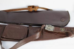 A John McNabb leather shotgun slip and a leather shotgun slip with Winchester badges attached to