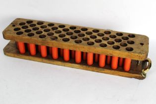A wooden cartridge reloading tray for fifty cartridges, with Eley, Kynoch cases (primed).