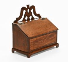 A 19th century oak salt box, with carved cresting rail above a lidded lower section.