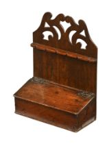 A 19th century oak spoon rack, the upper section with open fretwork decoration above a hinged box.