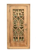 A bleached oak corner wall cupboard, having ecclesiastical fretwork central panelled door.