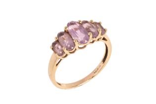 A 9 ct gold dress ring set with amethyst coloured stones, size U/V, 3 grams.