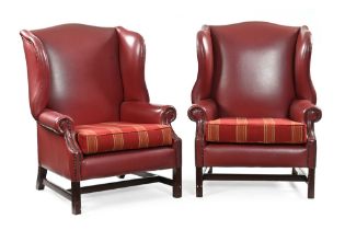 A pair of leather wing back armchairs, the seats upholstered in a red tartan material.