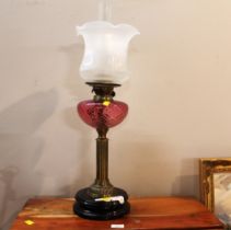 Brass column oil lamp with cranberry reservoir and etched shade,