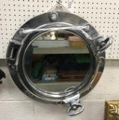 A modern chrome effect port hole style mirror,