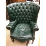 WITHDRAWN A buttoned green leather upholstered and studded wingback scroll arm chair in the George