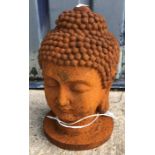 A cast metal figure of a Buddha's head, with rust style patination,