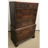 An early 19th Century oak chest on chest of two short over three long graduated drawers on a base