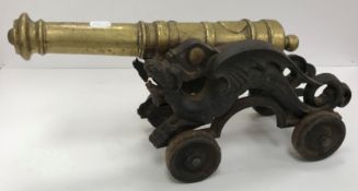 A circa 1900 bronze canon on cast iron wyvern or dragon decorated carriage 45 cm long x 16 cm wide