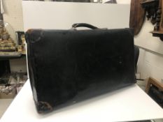 A Revelation black stained suitcase with leather corners together with three further suitcases and