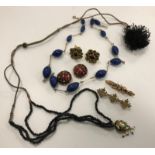 A collection of jewellery comprising a bar brooch, a yellow metal mounted blue bead necklace,