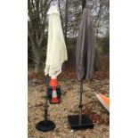 Two garden parasols and weighted bases