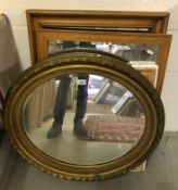 A circa 1900 oval giltwood and gesso framed wall mirror with bevel edge plate within a leaf and