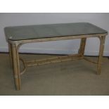 A modern bamboo framed rectangular conservatory table with textured glass top,