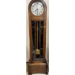 A 1930s oak cased long case clock, the domed top above a glazed panelled main door,