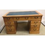A modern reproduction birdseye maple veneered double pedestal desk with tooled and gilded insert