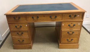 A modern reproduction birdseye maple veneered double pedestal desk with tooled and gilded insert