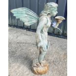 A cast metal figure of a fairy holding a shell, with verdigris style patination,