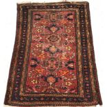 WITHDRAWN A Caucasian carpet, the central panel set with stylised floral motifs on a red ground,