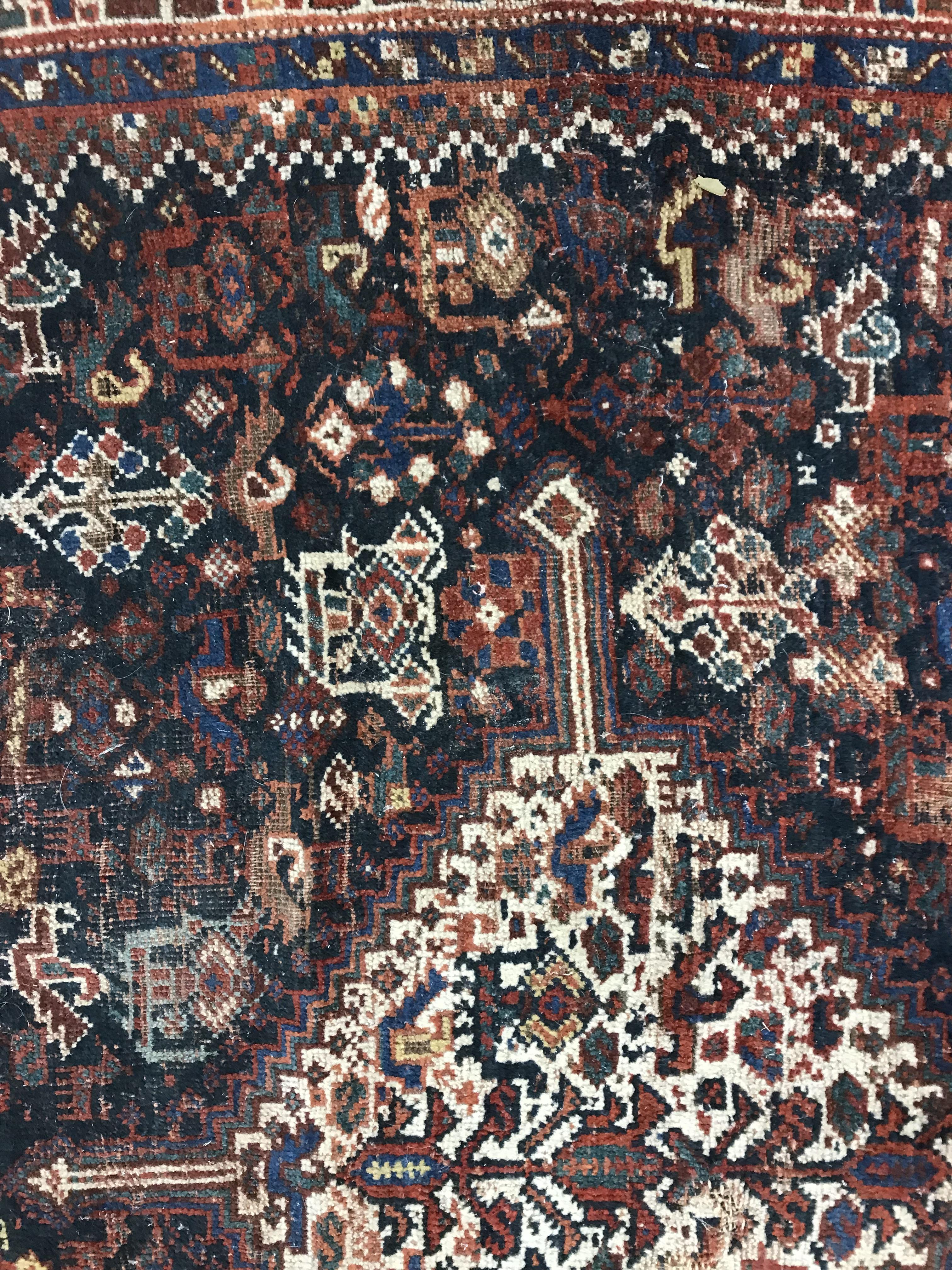 A Persian carpet, the central panel set with repeating medallions on a dark blue ground, - Image 32 of 93