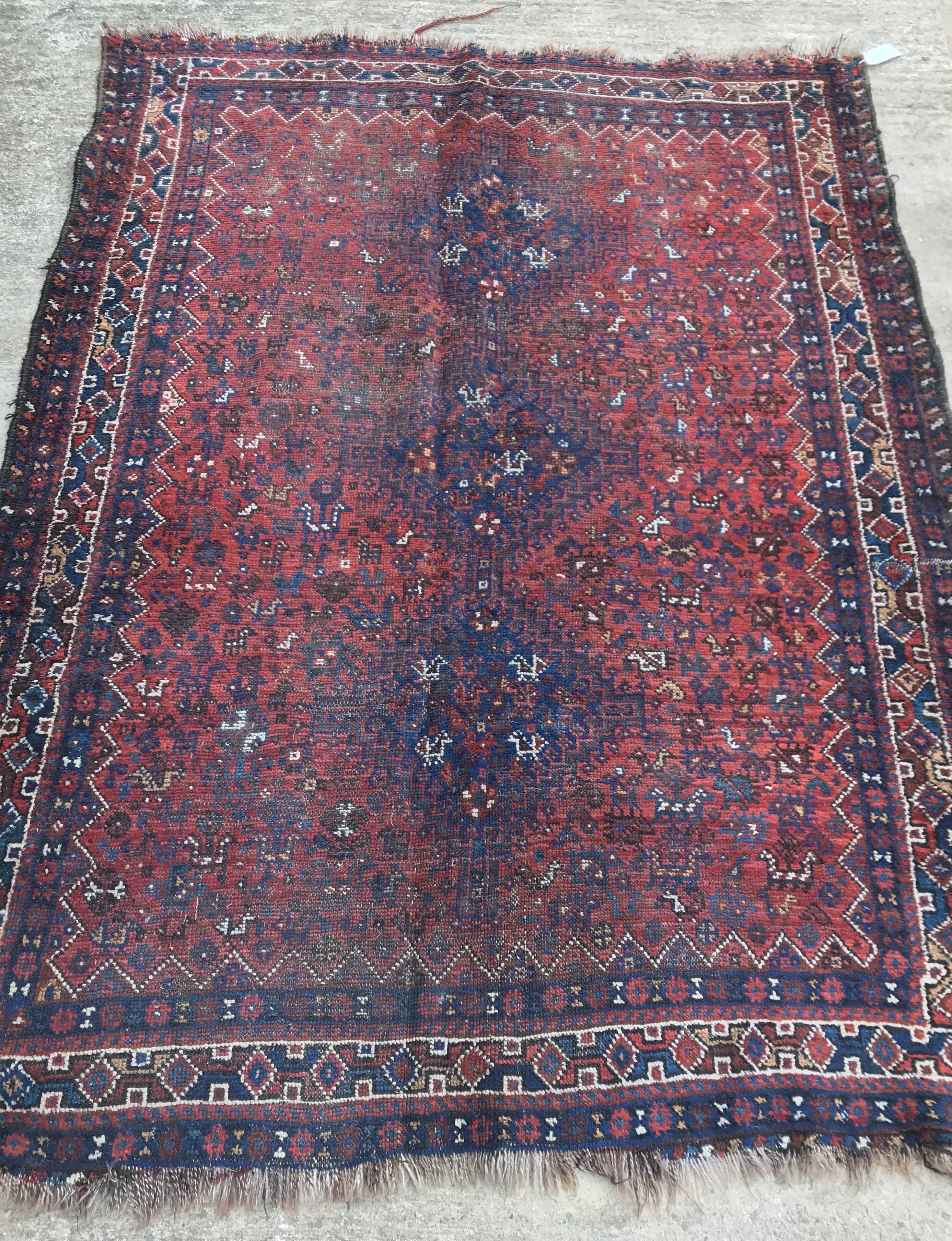 An early to mid-20th Century Persian red ground rug with repeating lozenge medallion decoration to - Image 3 of 7