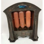 An early 20th Century copper electric fire in the Arts and Crafts manner with Ruskin type roundel