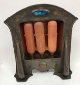 An early 20th Century copper electric fire in the Arts and Crafts manner with Ruskin type roundel