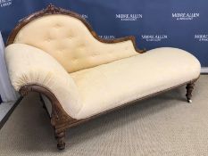 A Victorian carved walnut framed chaise longue with scroll end on turned and fluted tapering legs