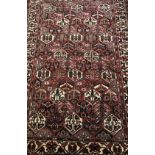 A Bokhara rug with all-over floral medallion decoration on a red ground,