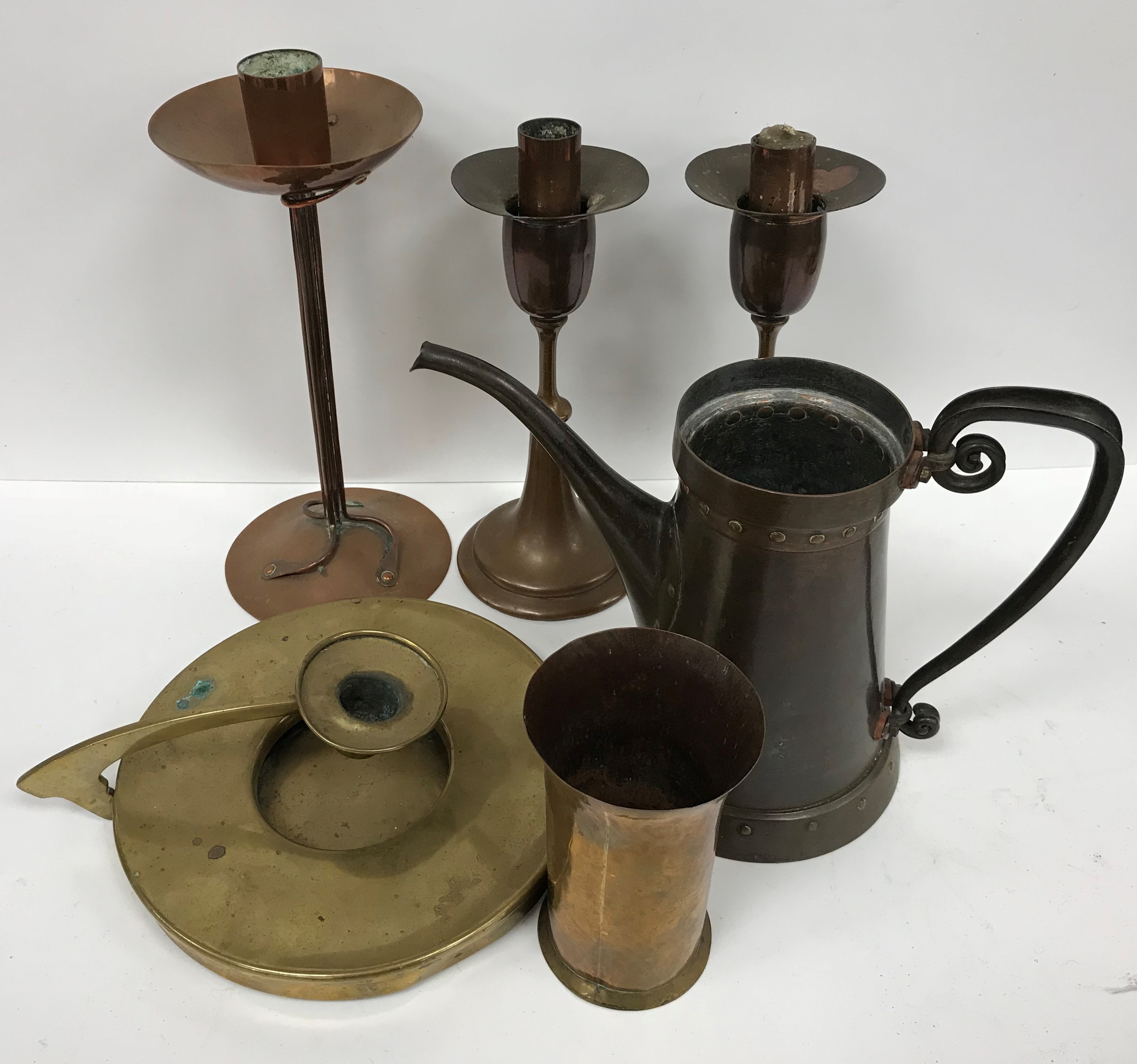 A collection of early 20th Century copper and brass ware comprising a copper candlestick with