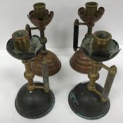 Two pairs of copper and brass candlesticks in the manner of Benson,