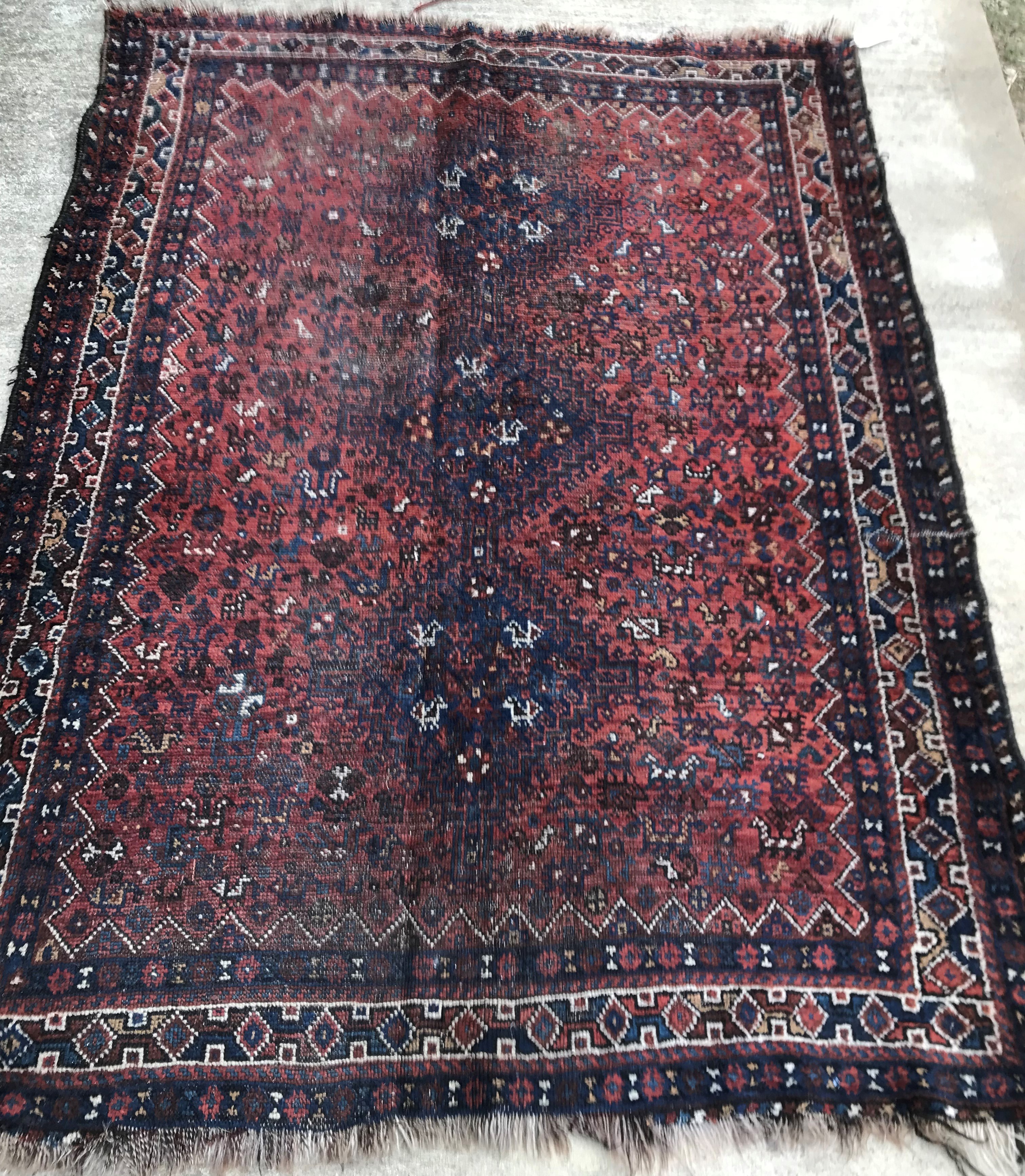 An early to mid-20th Century Persian red ground rug with repeating lozenge medallion decoration to - Image 2 of 7