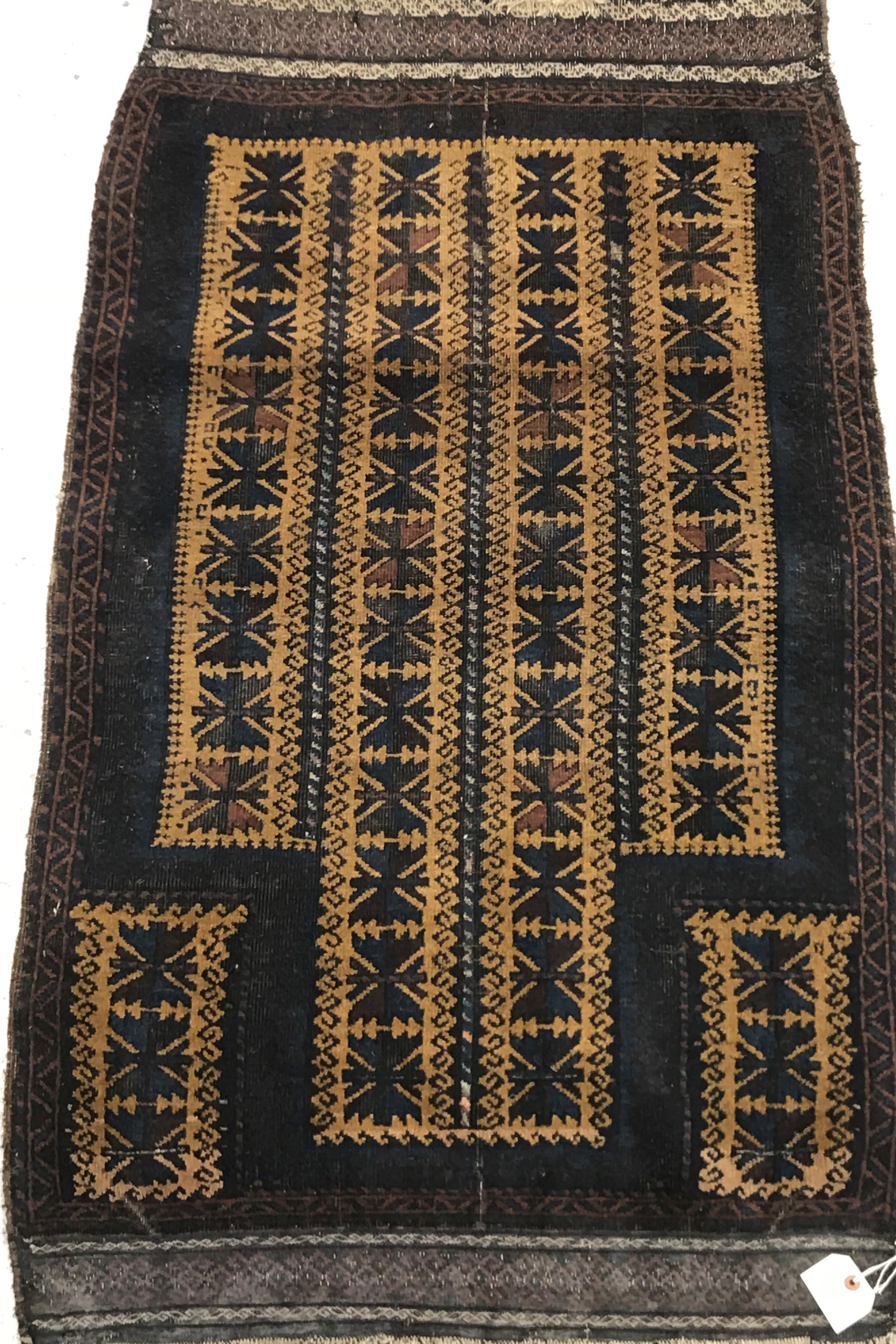 A Belouch prayer rug, the central panel set with geometric designs on a mustard ground,