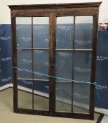 A stained pine two door glazed wall cabinet (front section only - no shelves),