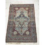 A vintage Persian rug, the central panel set with scrolling medallion with all-over floral,