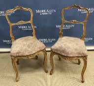 A pair of 19th Century French gilded bedroom chairs with shell and C scroll decoration with