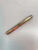 A rolled gold pen with engine turned decoration inscribed "Tiny"