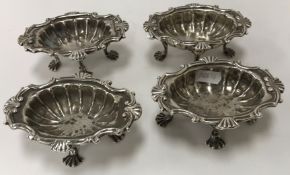 A set of four George II silver salts with shell decoration, raised on four shell feet,