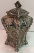 An Edwardian silver tea caddy of bombé form with embossed acanthus and shell decoration raised on