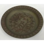 An Indian engraved brass and silvered circular dish with all-over foliate decoration,