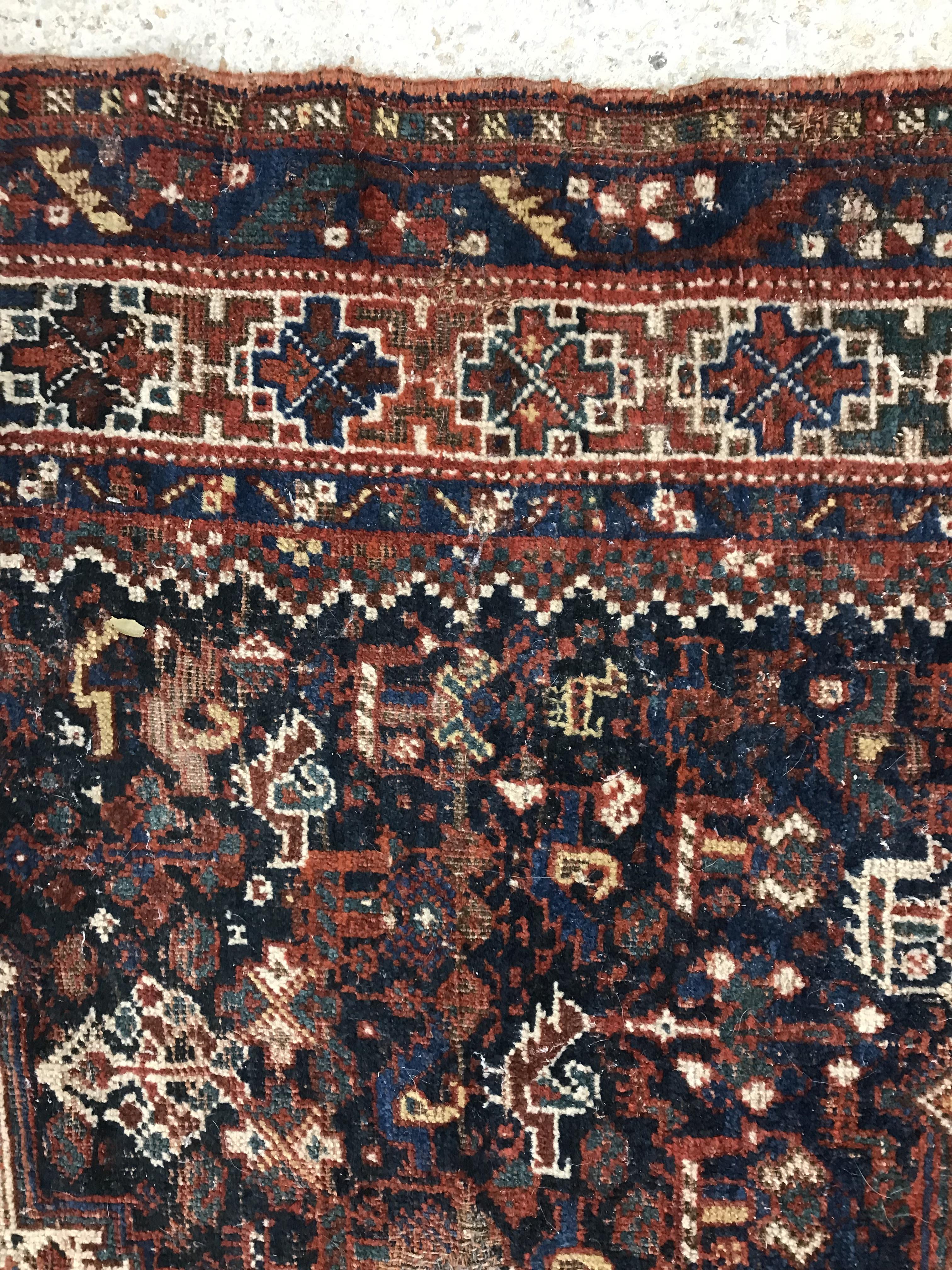 A Persian carpet, the central panel set with repeating medallions on a dark blue ground, - Image 30 of 93