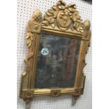 A 19th Century giltwood and gesso framed wall mirror, the top with ribbon,