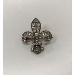 A silver and nine carat rose gold mounted old cut diamond brooch of fleur de lys form,