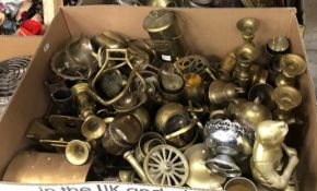 Two boxes of assorted brass and other metal wares to include candlesticks, bells, chargers, figures,