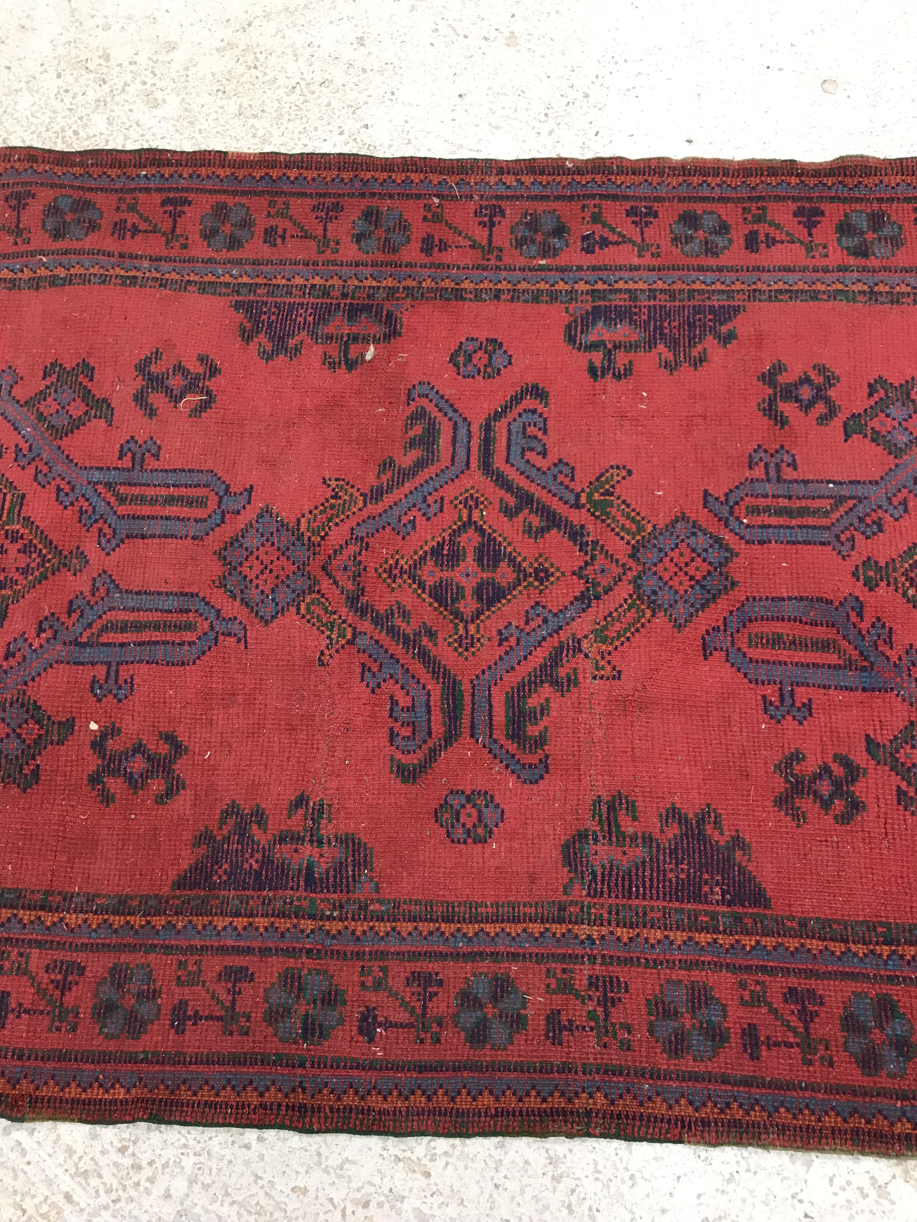 A Donegal style runner, the central panel set with repeating geometric design on a red ground, - Image 10 of 18