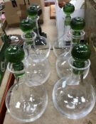 A set of six late 20th Century clear glass Murano decanters with green glass ribbed stoppers,