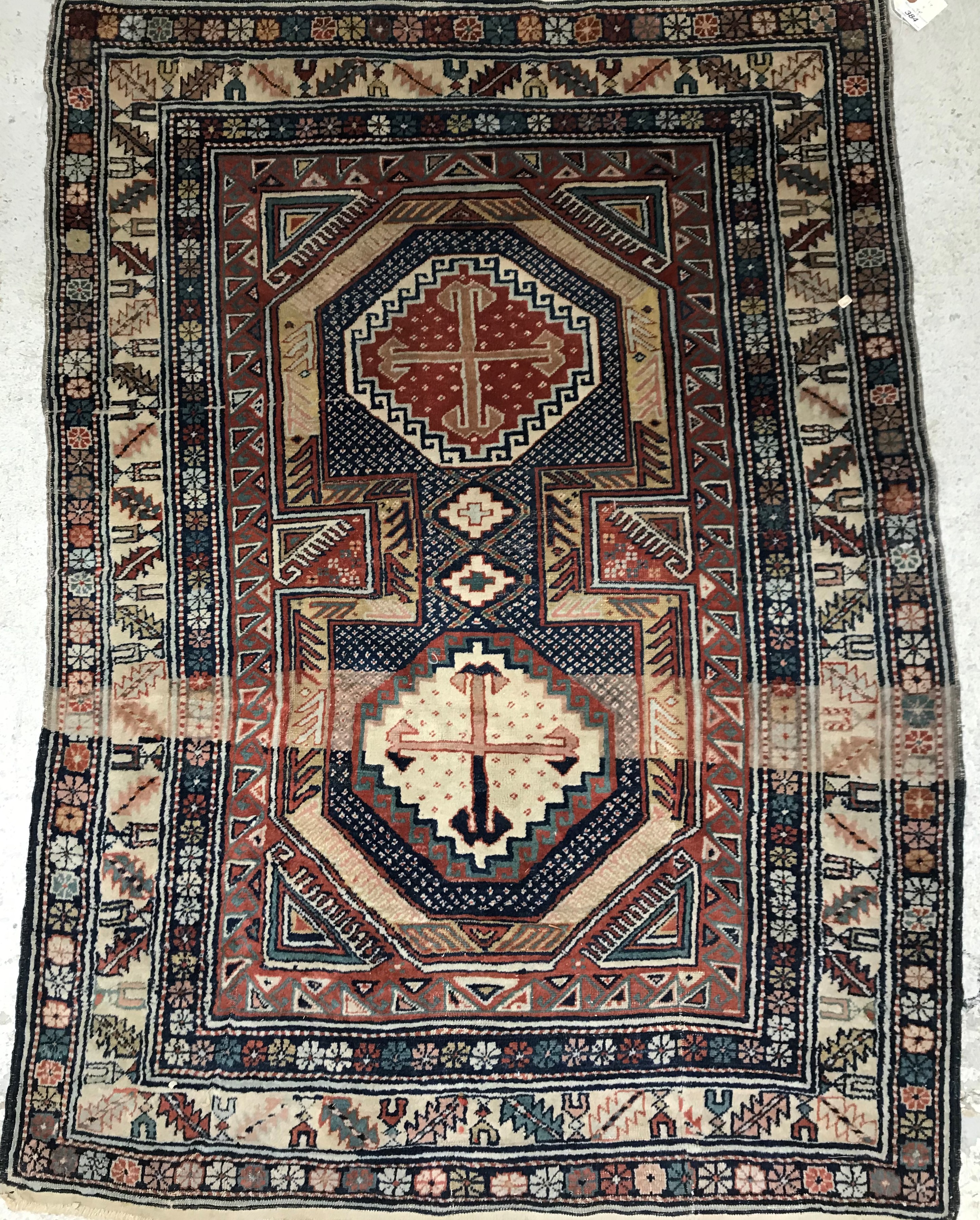 A vintage Shirvan rug, the cental panel set with two medallions on a blue and cream ground,