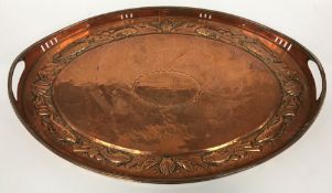 An early 20th Century Newlyn School tray of oval form with pierced galleried edge and two handles